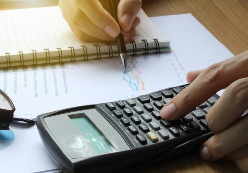 Hand use calculator on the office desk investment and property for concept