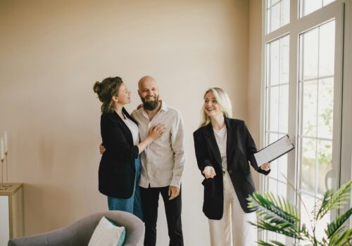 Real estate agent demonstrates a new apartment to a happy couple. Buying a property.