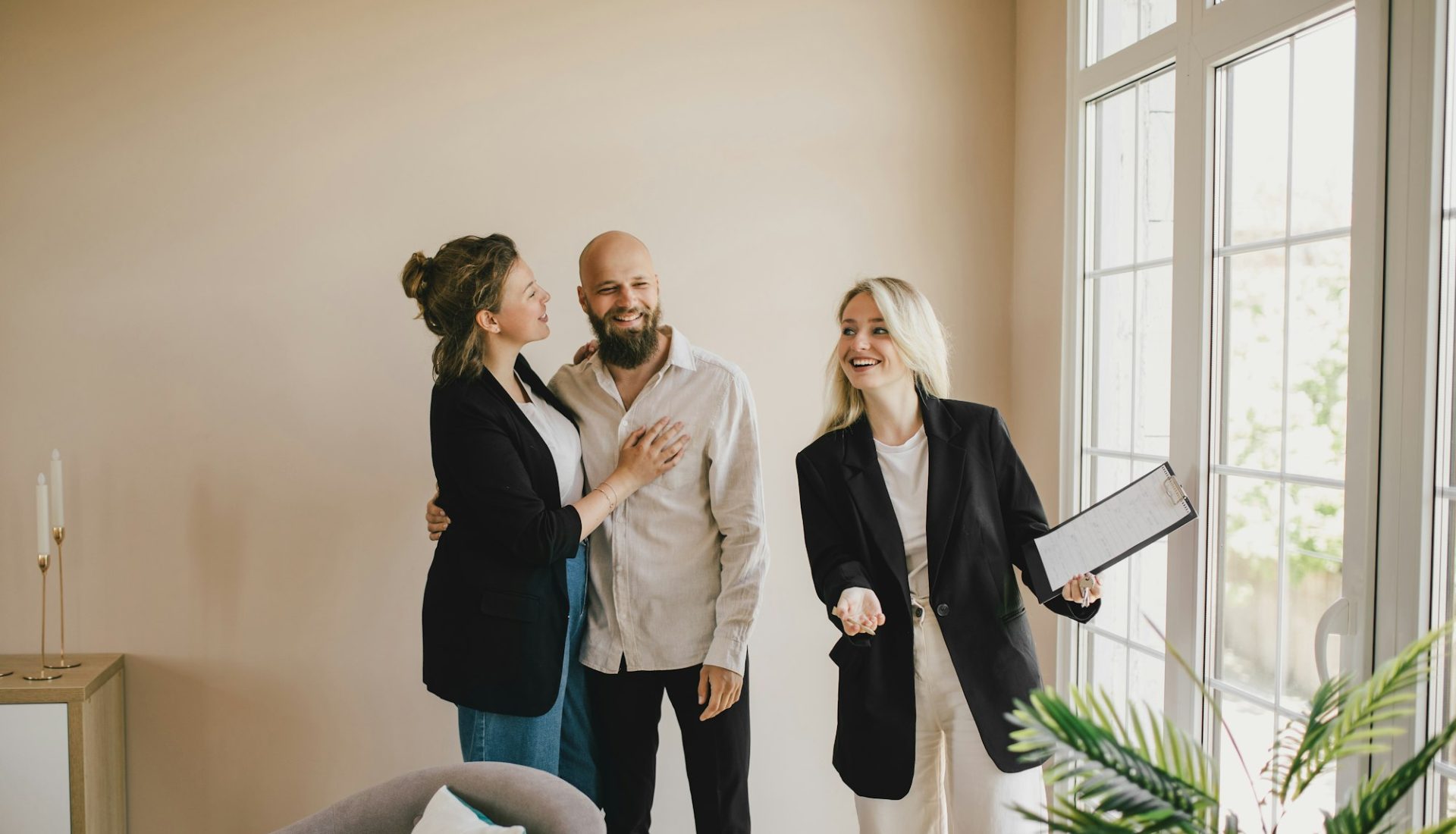 Real estate agent demonstrates a new apartment to a happy couple. Buying a property.